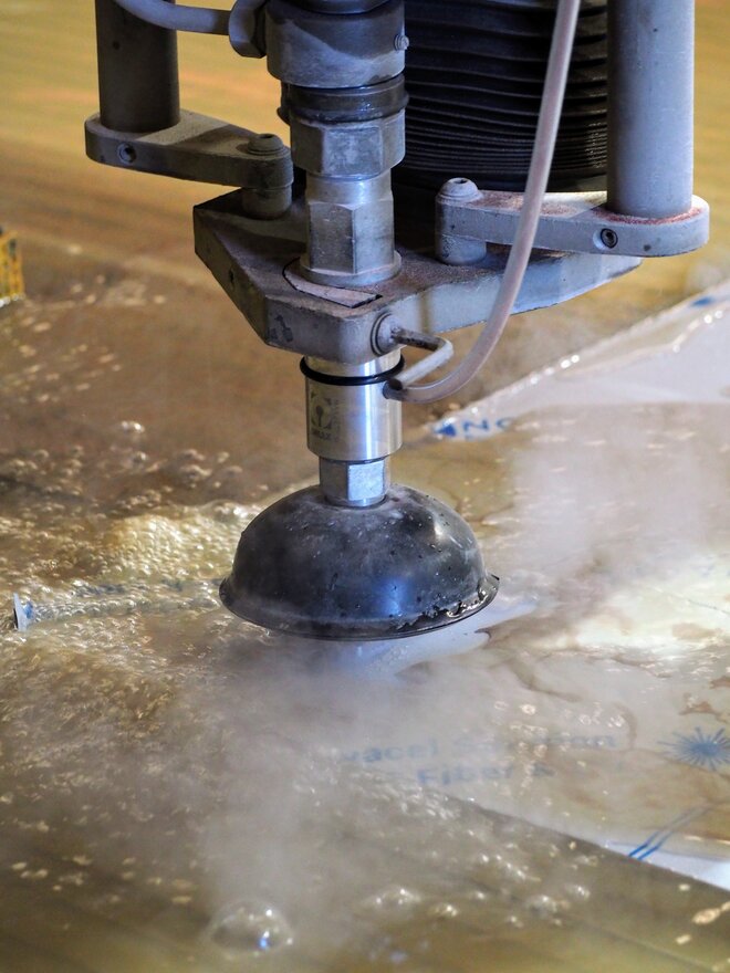 CNC waterjet cutting machine at ORCA Engineering precisely cutting a metal sheet with high-pressure water